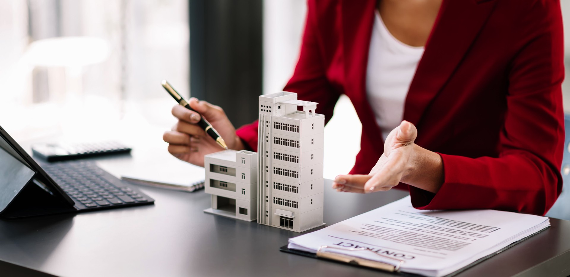 Real estate broker agent presenting and consult to customer to decision making sign insurance form agreement, home model, concerning mortgage loan offer in office